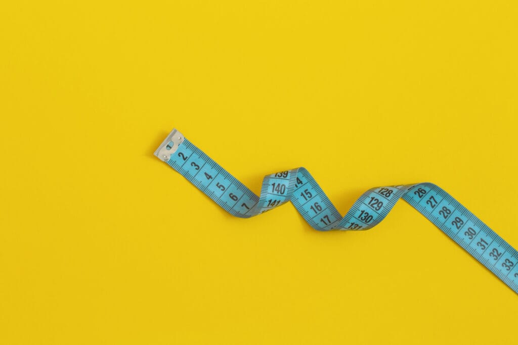 Measuring tape on yellow background